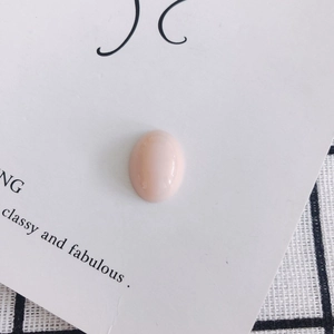 Detailed view of an oval pink cabochon resin stone for DIY craft accessories