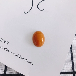 Close-up of polished orange oval resin cabochon for DIY shoe and phone case crafts