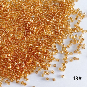Macro shot of 2mm silver-lined golden glass bugle beads for DIY jewelry making