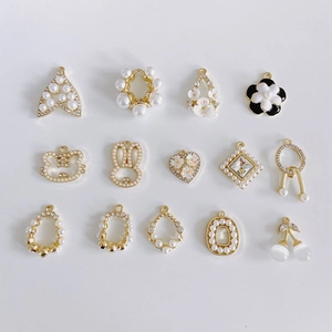 Detailed selection of golden alloy jewelry pendants with pearls, rhinestones and enamel motifs