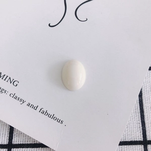 Detailed view of an oval white resin cabochon bead for DIY shoe and phone case decor