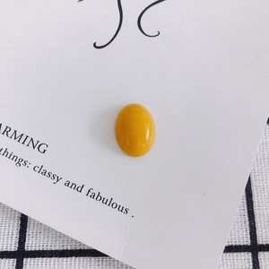 Close-up of a glossy yellow oval resin gemstone for DIY jewelry and phone case crafts