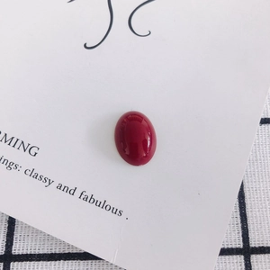 Close-up of polished oval red resin cabochon stone for DIY phone case and shoe charms