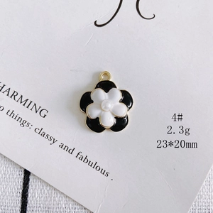Macro shot of camellia flower charm with black enamel and pearl for DIY jewelry