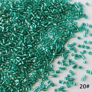 Detailed macro shot of 2mm teal cylinder glass beads with metallic inner core for DIY