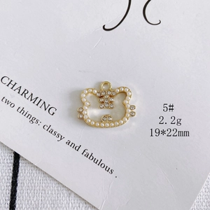 Detail view of gold alloy kitten charm with pearl inlay and crystals, size 19x22mm