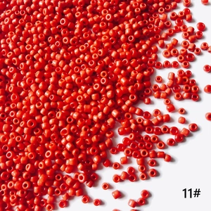 Gros plan de perles de rocaille rouges 2mm pour création de bijoux et artisanat