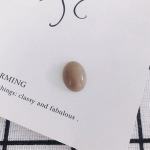 Close-up of a smooth oval khaki resin cabochon bead for DIY jewelry and phone case crafts