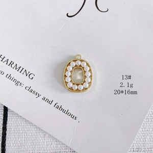 Detail of oval gold alloy pendant with white pearl border for DIY jewelry making