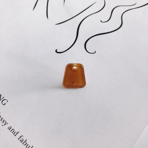 Macro detail of amber trapezoid resin earring pendant with glitter and top drill hole