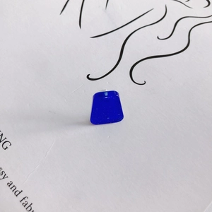 Detailed view of blue glitter resin trapezoid earrings on a minimalist white card