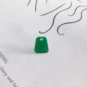 Macro detail of green trapezoid resin pendant with fine glitter and pre-drilled hole