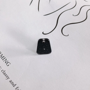Macro view of trapezoid resin earring pendant with black starry glitter and top hole