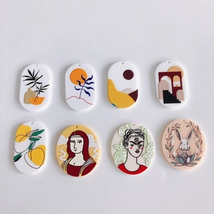 Flat lay of eight colorful acrylic jewelry charms featuring artistic rabbit and figure reliefs