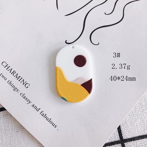 Macro view of acrylic oval pendant with abstract landscape art for DIY jewelry
