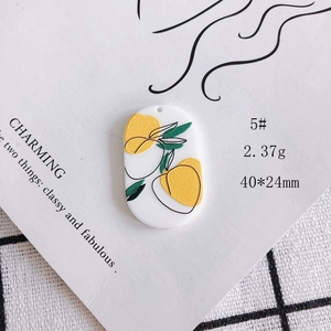 Detail view of 40x24mm acrylic oval pendant with yellow lemon and green leaf pattern