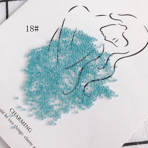 Detailed view of 2mm translucent blue glass seed beads on artistic white card display