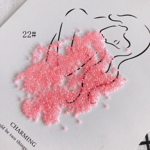 Macro shot of 2mm pink glass seed beads style 22# on artistic card for DIY jewelry