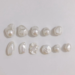 Detailed view of 11 assorted cream white baroque pearls with irregular natural textures