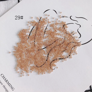 Macro shot of 2mm champagne glass seed beads on a decorative white background card