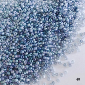 Macro shot of 2mm iridescent AB glass seed beads in pale blue and violet for DIY jewelry