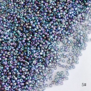 Macro view of 2mm rainbow AB glass seed beads with metallic luster for DIY jewelry making