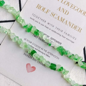 Polierte grüne unregelmäßige Steinkette auf elegantem weißen Hochzeitskartenhintergrund