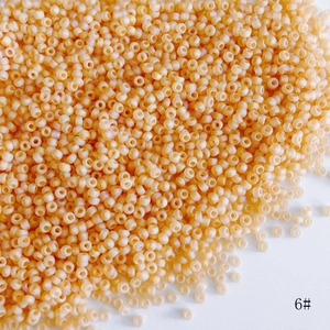 Close-up of 2mm light orange frosted glass seed beads for DIY jewelry making