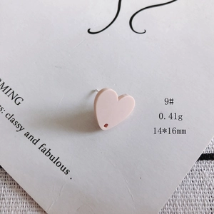 Dettaglio macro di un ciondolo a cuore in acrilico rosa opaco 14x16mm con foro praticato