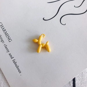 Detailed close-up of a bright yellow balloon dog charm with a smooth glossy finish