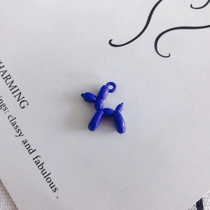 Macro view of a dark blue abstract balloon dog earring pendant with charming text background