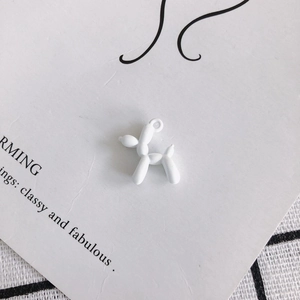 Matte white balloon dog charm for DIY jewelry making on a stylish decorative background