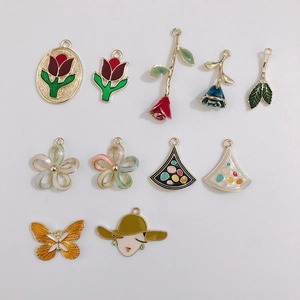 Detailed view of assorted enamel alloy charms for DIY jewelry making with floral patterns