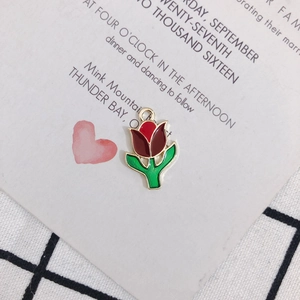 Detailed view of tulip enamel charm with red petals and green leaves for DIY jewelry
