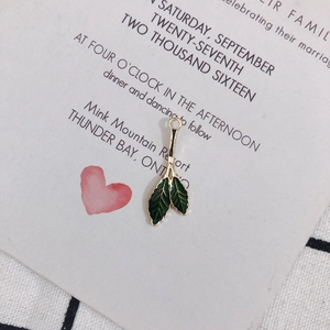 Close-up of green enamel double-leaf charm with gold alloy edges and realistic veins