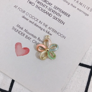 Macro detail of enamel flower charm with gold trim and colorful petals for DIY jewelry