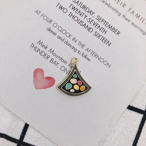 Detail of fan-shaped alloy pendant with black enamel and colorful polka dots