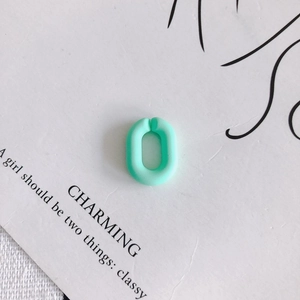 Vue macro d'un anneau de connexion ovale vert menthe mat en résine pour bijoux DIY