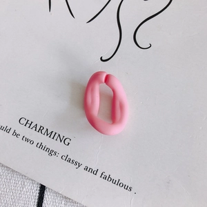 Vue macro d'un accessoire de bijoux boucle ouverte en acrylique rose mat sur carte