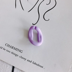 Gros plan d'un anneau en acrylique violet mat sur une carte de présentation blanche