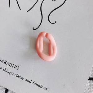 Détail de maillon de boucle d'oreille en acrylique rose mat sur une carte d'affichage