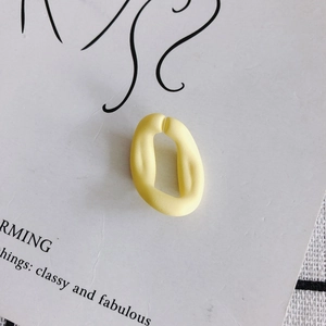 Détail macro du maillon ouvert en acrylique jaune crème mat pour la création de bijoux