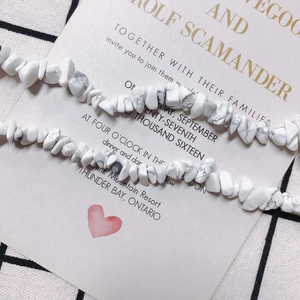Makro-Detail des unregelmäßigen weißen Steinarmbands mit grauer Marmortextur