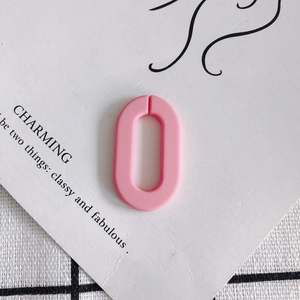 Makroaufnahme von rosa gefrosteten Acryl-Oval-Schmuckteilen auf eleganter weißer Karte