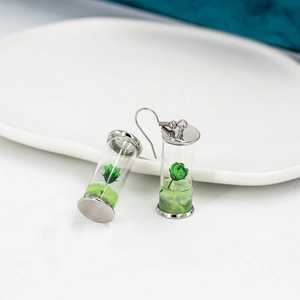 Silver drop earrings with glass drift bottle containing miniature green dried flowers