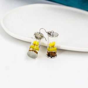 Silver-plated earrings with drifting glass bottles containing dried yellow flowers