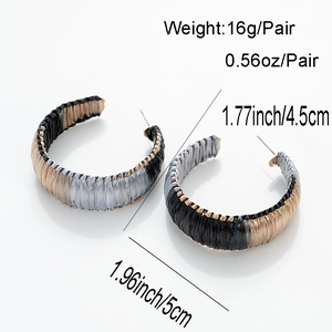 Detail view of woven C-shape hoop earrings with 5cm diameter and 16g weight specs
