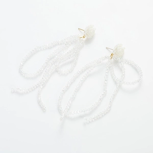 Macro view of white floral stud earrings with cascading clear beaded long tassels