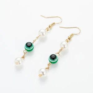 Exotic evil eye dangle earrings with white pearls and gold chain links on white background