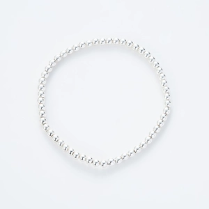 Detalle macro de la pulsera elástica con esferas plateadas pulidas y diseño minimalista